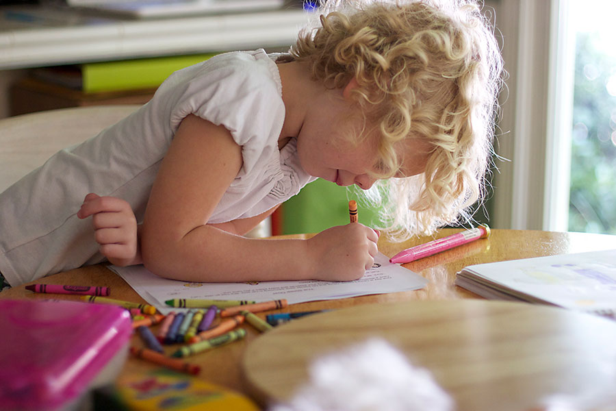 Girl drawing with crayons